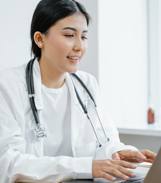 A female doctor reviewing a patient's case in her computer.