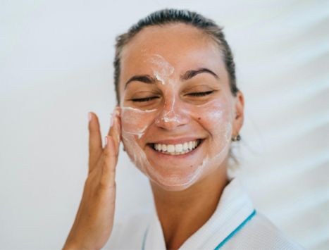 Female Patient putting skin-care on after having received treatment from her Colombian dermatologist.