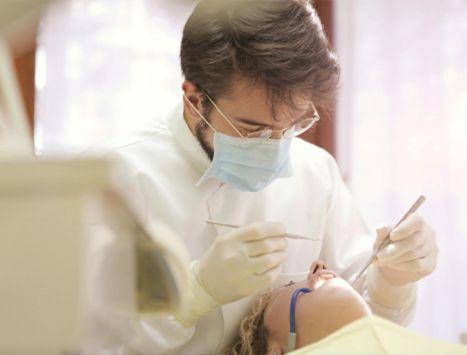 Dentist performing root canal treatment under magnification loupe in a Colombian dental clinic
