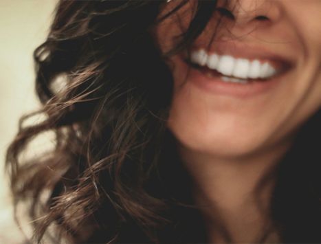 Female MedValet patient smiling after receiving orthodontic adjustment from dentist in a Medellín dental clinic