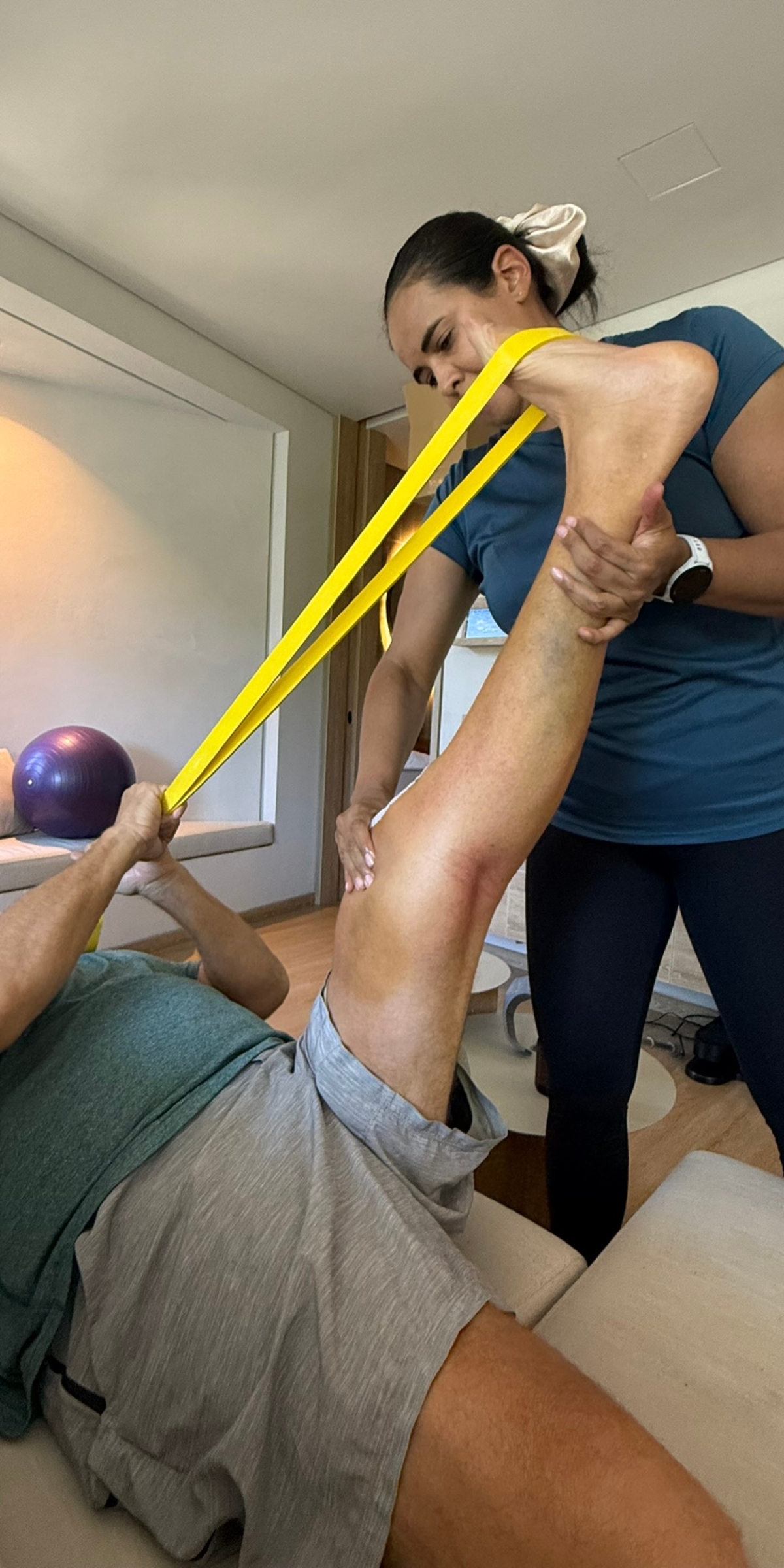 Physiotherapist guiding a knee replacement patient through recovery exercises at an apartment in El Poblado.
